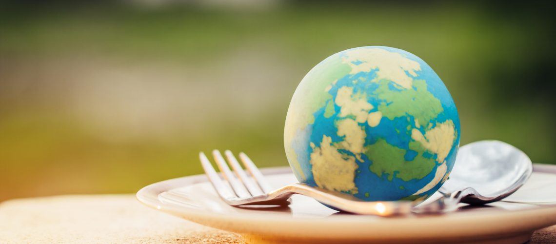 Globe model placed on plate with fork spoon for serve menu in famous hotels. International cuisine is practiced around the world often associated with specific region country. World food inter concept